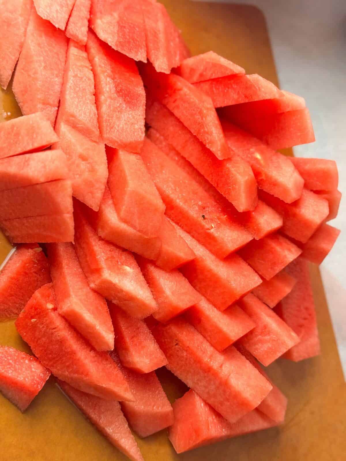 Perfect Watermelon Sticks juicy, refreshing watermelon sticks on a cutting board