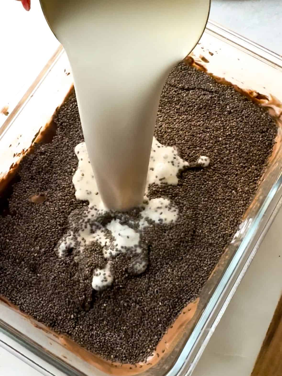 Steps To Make Mocha Chia Pudding Cake adding chia seeds, brewed coffee, and almond over chocolate base