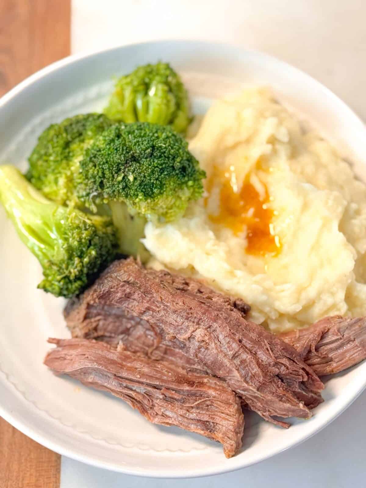 Beef Roast with Mashed Potatoes Roast beef served with creamy mashed potatoes, broccoli, and carrots