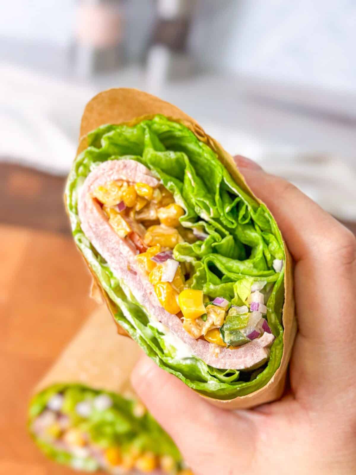 Healthy turkey pastrami lettuce wrap with crisp lettuce, red onion, and avocado mayo