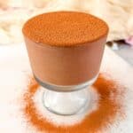 A close-up of a jar of high-protein chocolate pudding with a creamy, dense texture and a smooth cacao finish.