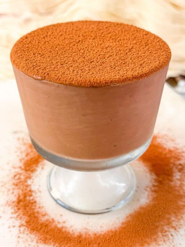 A close-up of a jar of high-protein chocolate pudding with a creamy, dense texture and a smooth cacao finish.