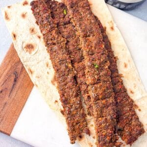 a close-up shot of baked pan kafta kebabs served on flatbread