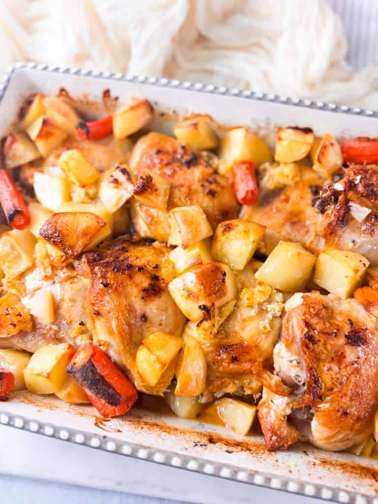 Lemon Garlic Roasted Chicken Thighs with Potatoes and Carrots a top shot of roasted chicken thighs baked in a large baking dish with golden potatoes and caramelized carrots