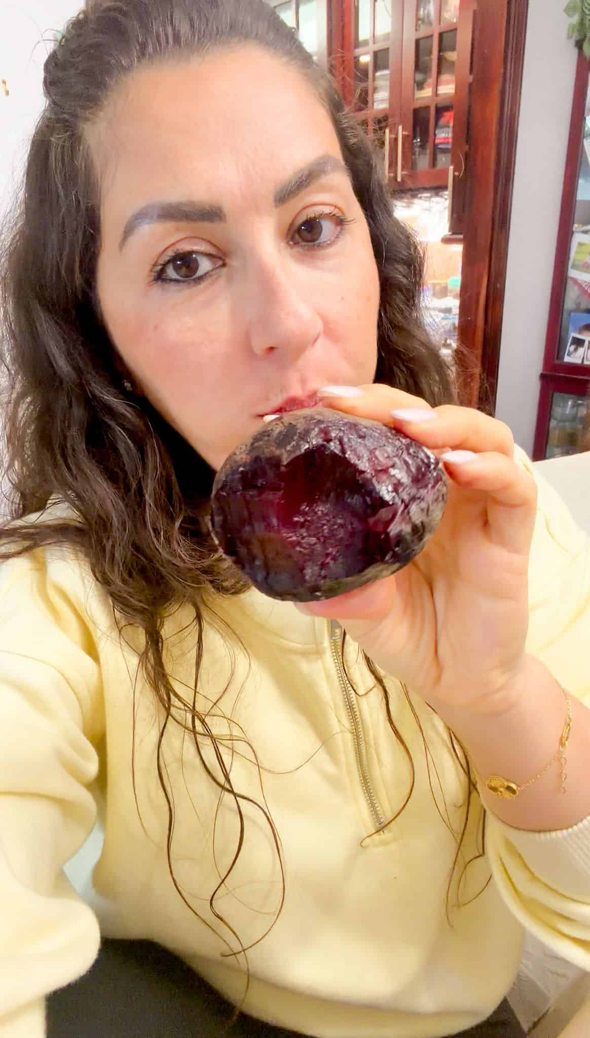 Best Oven Roasted Beets Lama is holding a roasted beet with one bite out