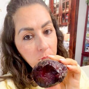 Lama is holding a roasted beet with one bite out