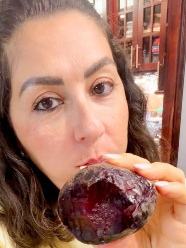 Lama is holding a roasted beet with one bite out