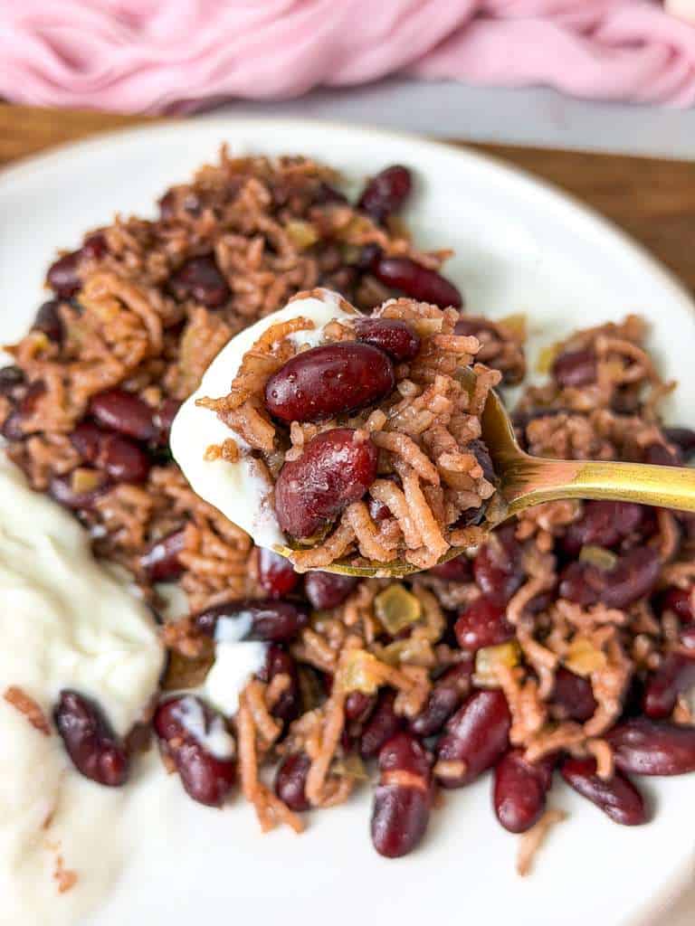 Lebanese Red Beans and Rice (Lubya Hamra) Spoonful of Lebanese red beans and rice with creamy yogurt on the side