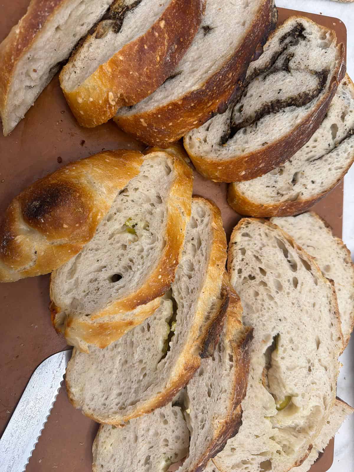 Overnight Sourdough Bread Sliced overnight sourdough bread with open crumb and savory swirls on a wooden cutting board